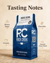 Load image into Gallery viewer, Rock Creek Coffee Roasters House Blend coffee bag centered on a warm neutral background with a “Tasting Notes” header and callouts for brown sugar, chocolate, creamy, and smooth clean finish.